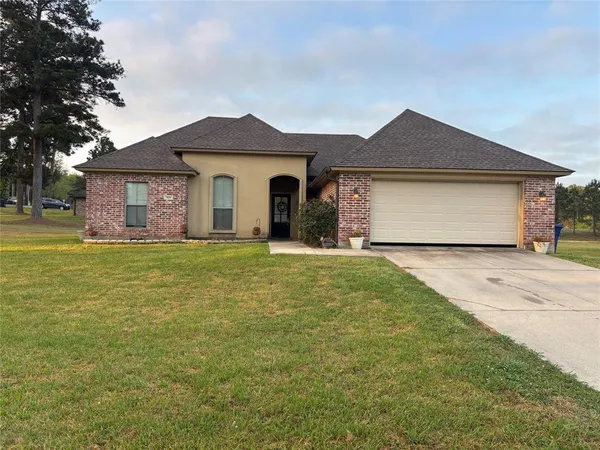 a front view of a house with yard and garage