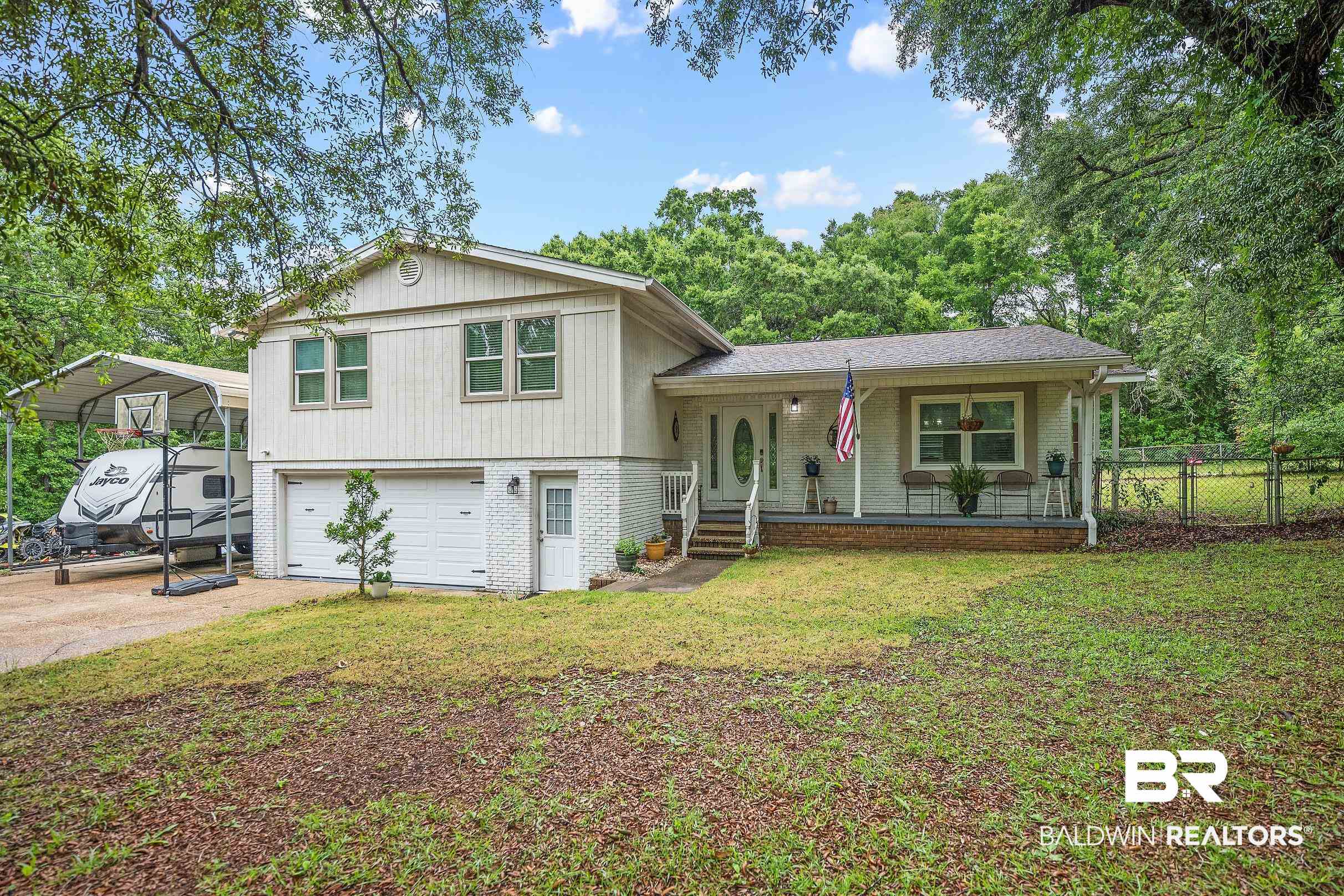 33129 Antietam Road Lillian, AL 36549 - Photo 1 of 31 Split-level residence featuring a covered front porch, two-car garage, and a side carport