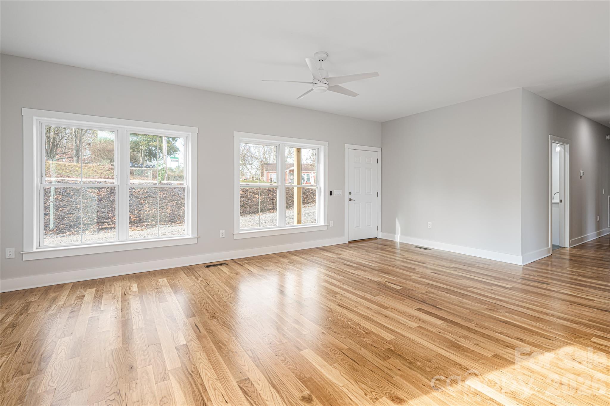 93 Locust Grove Road Weaverville, NC 28787 - Photo 12 of 26 a view of an empty room with wooden floor and a window