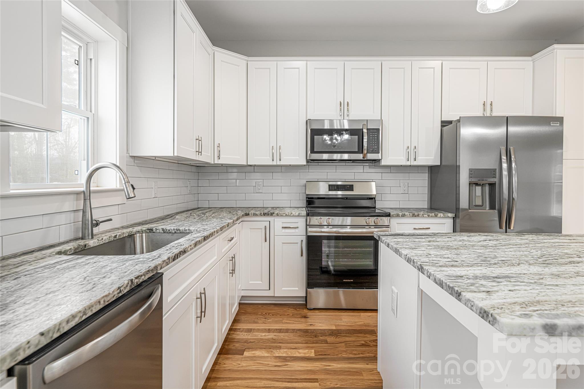 93 Locust Grove Road Weaverville, NC 28787 - Photo 7 of 26 a kitchen with stainless steel appliances granite countertop a sink stove and refrigerator