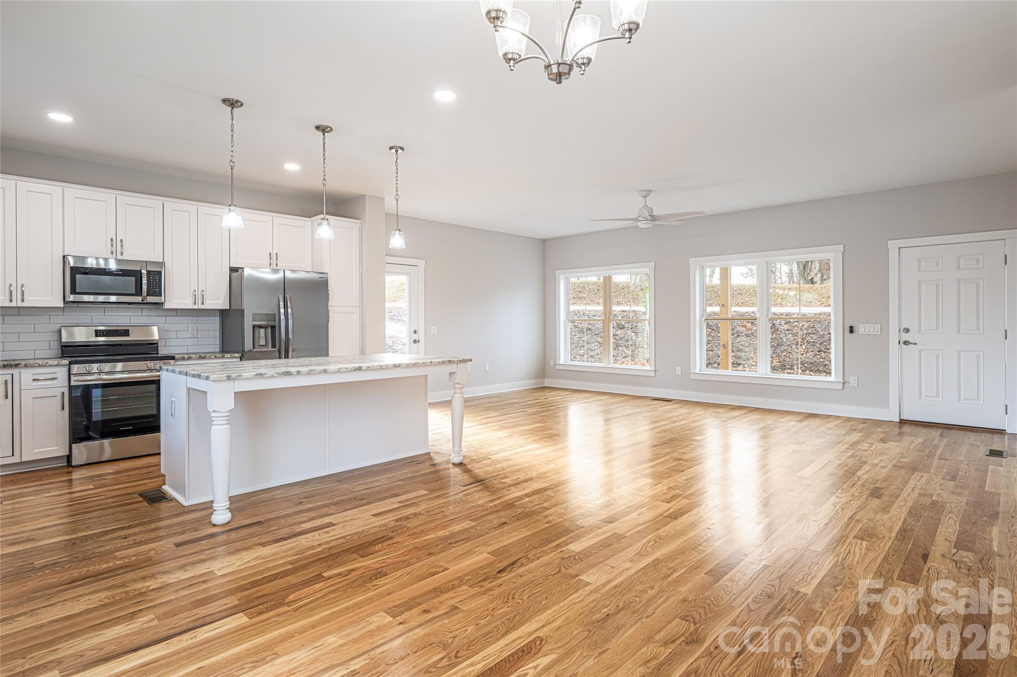 93 Locust Grove Road Weaverville, NC 28787 - Photo 9 of 26 a large kitchen with granite countertop a large counter top stainless steel appliances and wooden floors