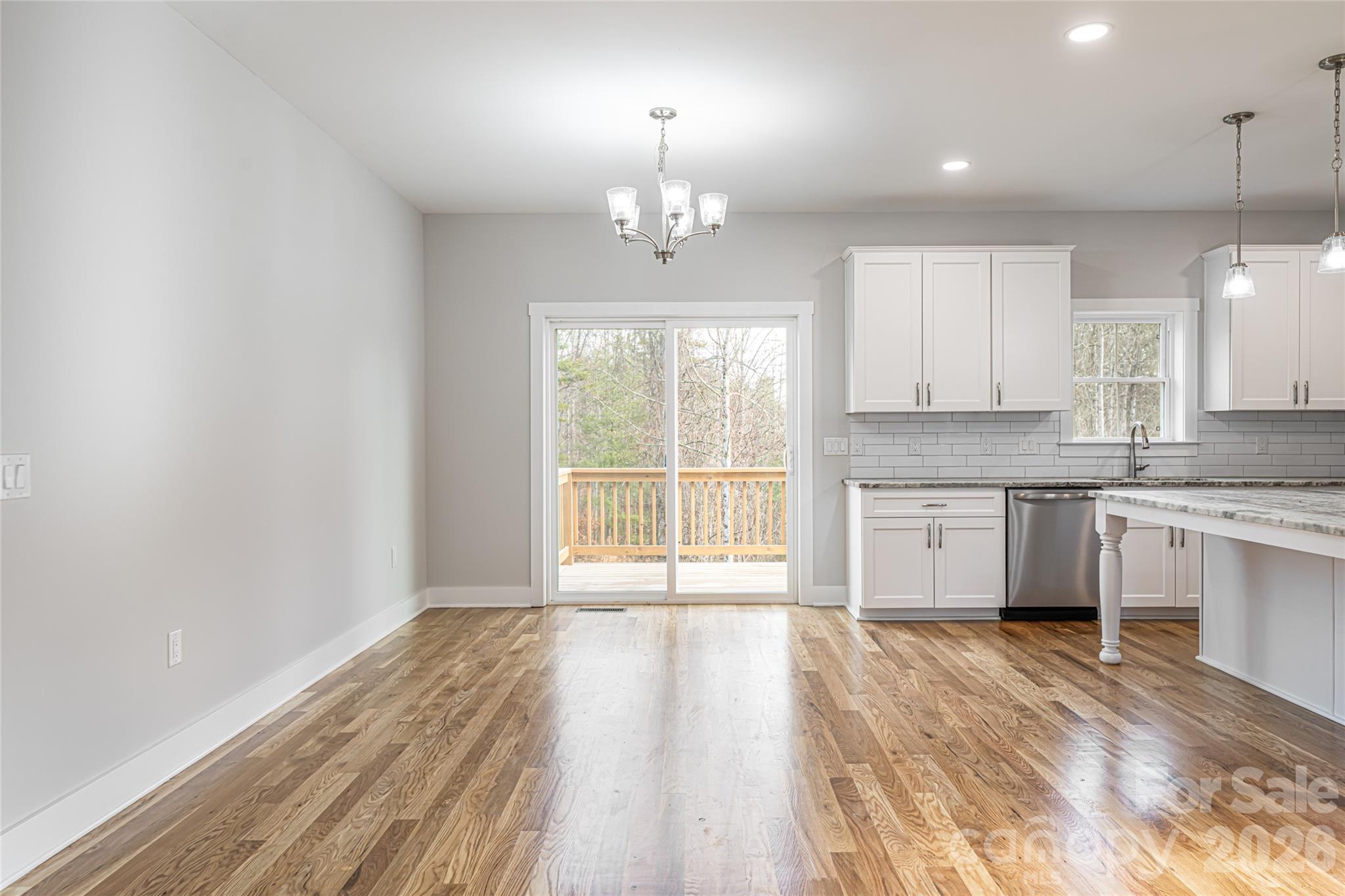 93 Locust Grove Road Weaverville, NC 28787 - Photo 10 of 26 a large kitchen with granite countertop a stove top oven a sink dishwasher and white cabinets with wooden floor