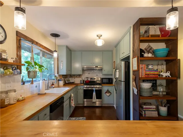 a kitchen with stainless steel appliances granite countertop a stove a sink and a refrigerator