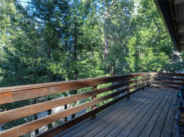 a view of a backyard with wooden fence and a large tree