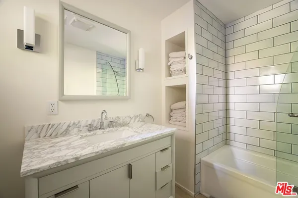 a bathroom with a granite countertop sink and a mirror