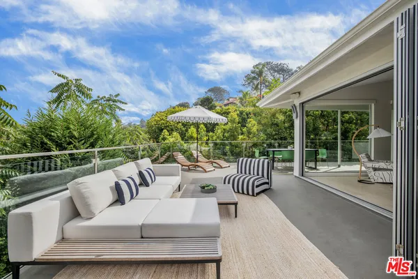 a view of a patio with couches table and chairs and potted plants