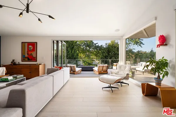 a living room with patio furniture and a potted plant