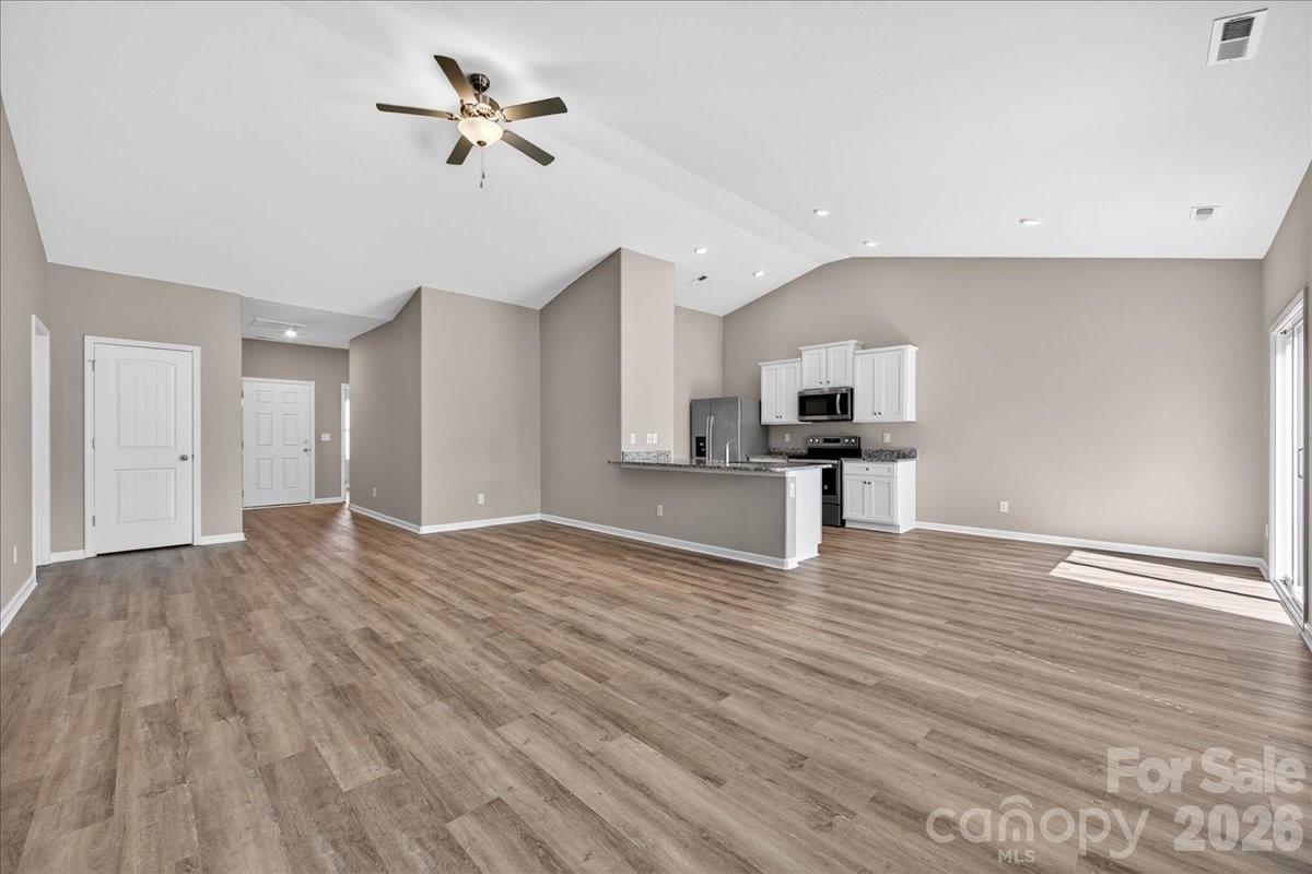 4322 One Mile Way Charlotte, NC 28215 - Photo 13 of 48 a view of a kitchen with wooden floor and a ceiling fan