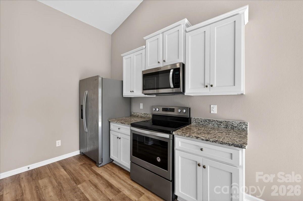 4322 One Mile Way Charlotte, NC 28215 - Photo 17 of 48 a kitchen with stainless steel appliances granite countertop a stove a microwave and a refrigerator