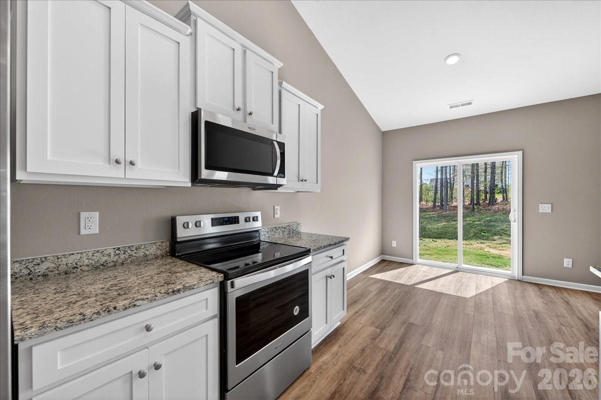 4322 One Mile Way Charlotte, NC 28215 - Photo 18 of 48 a kitchen with granite countertop a stove a sink and a microwave