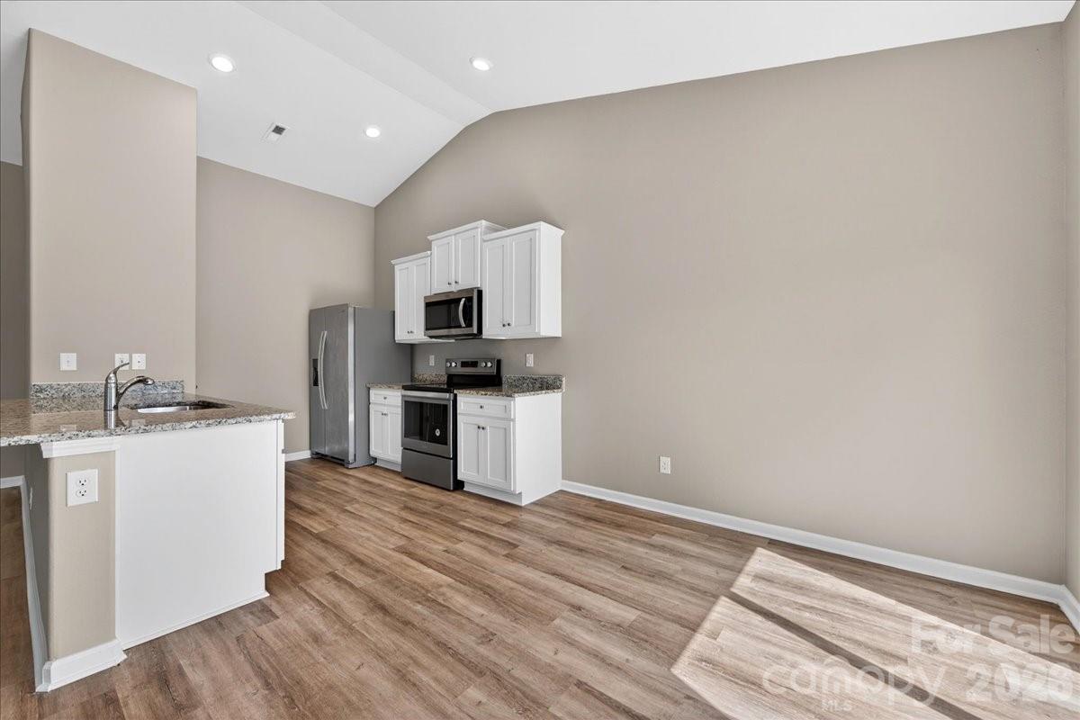 4322 One Mile Way Charlotte, NC 28215 - Photo 20 of 48 a kitchen with white cabinets and appliances