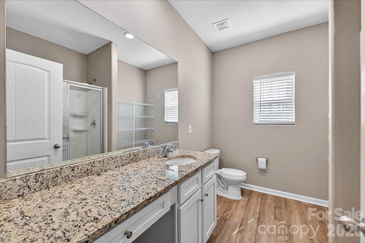 4322 One Mile Way Charlotte, NC 28215 - Photo 29 of 48 a bathroom with a granite countertop sink a toilet and shower