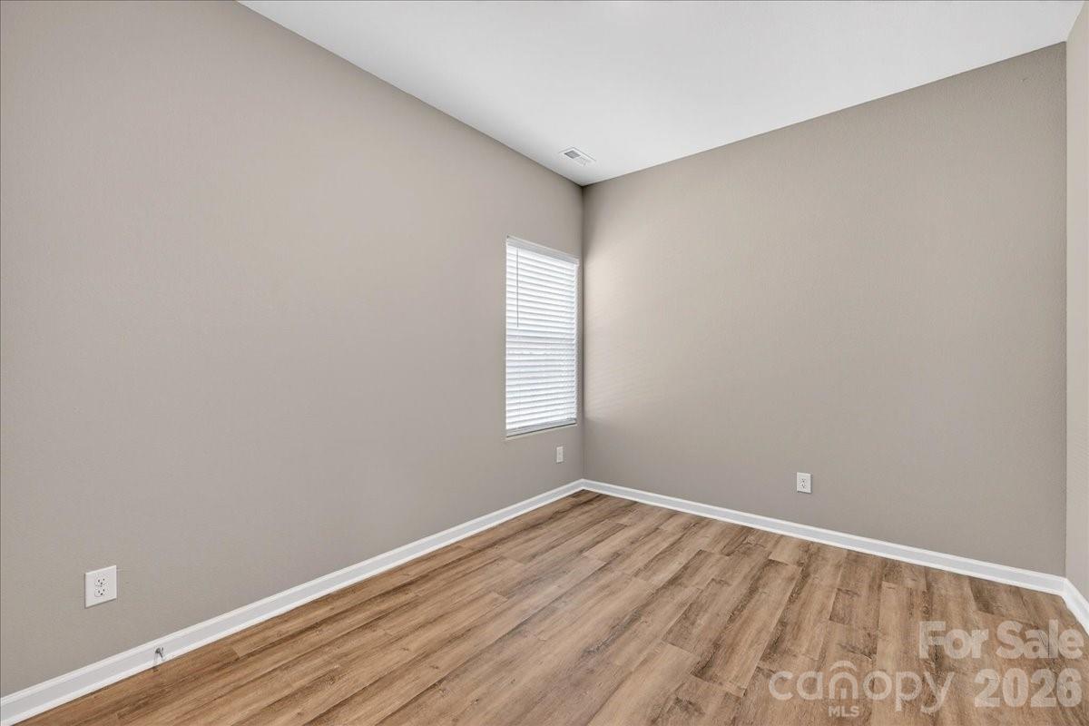 4322 One Mile Way Charlotte, NC 28215 - Photo 39 of 48 a view of an empty room with wooden floor and a window