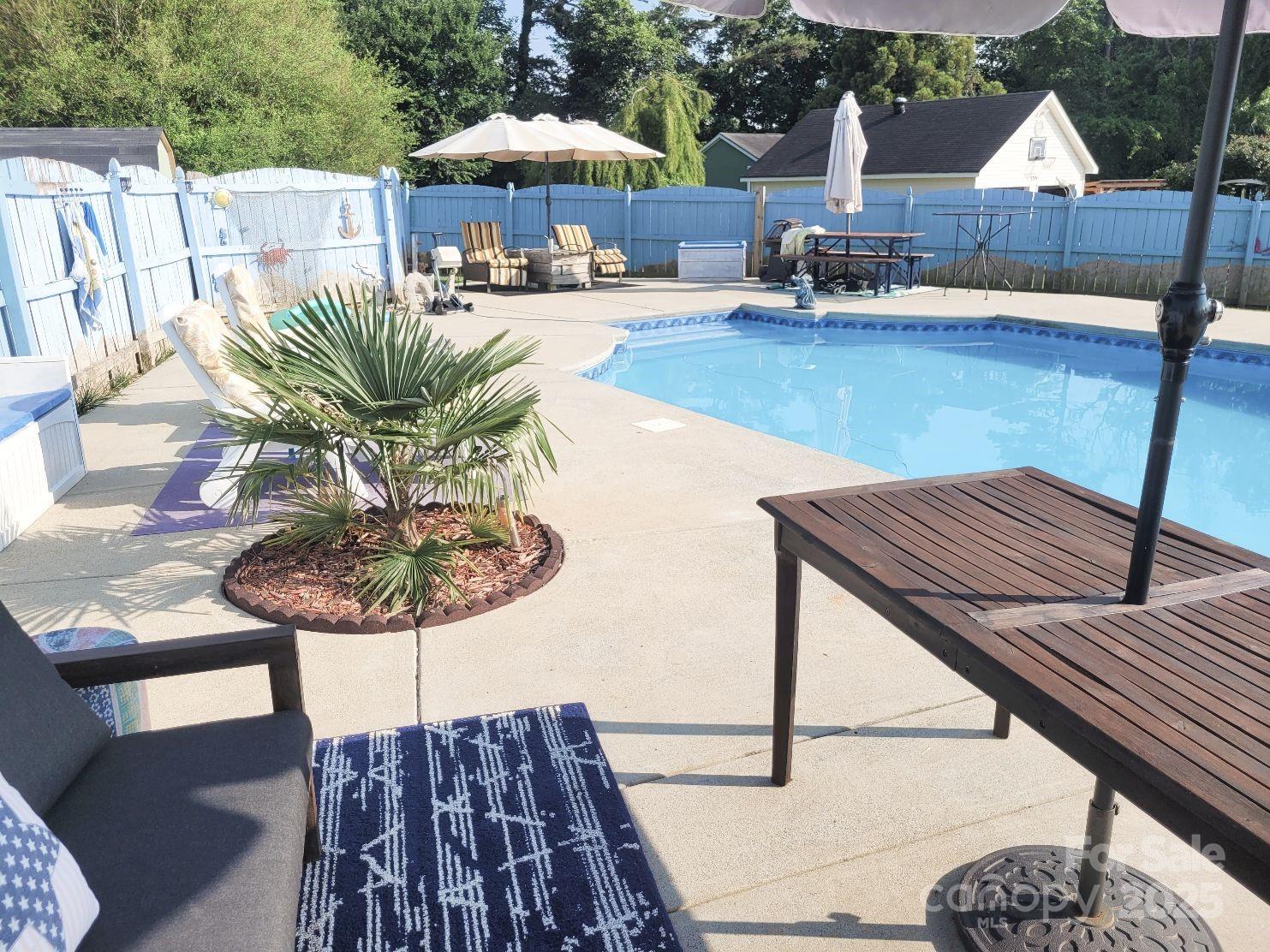 3731 Maple Knoll Drive Monroe, NC 28112 - Photo 38 of 40 a view of a roof deck with table and chairs under an umbrella with wooden floor