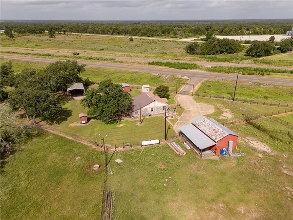a view of a house with a big yard and a large trees