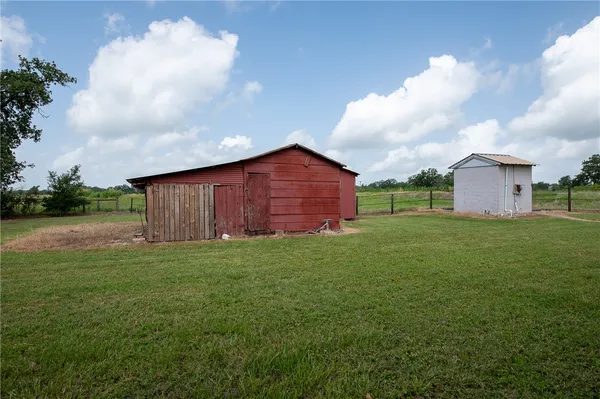 a view of a house with a large tree and a yard