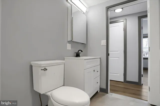 a side of a yard with wooden fence and trees