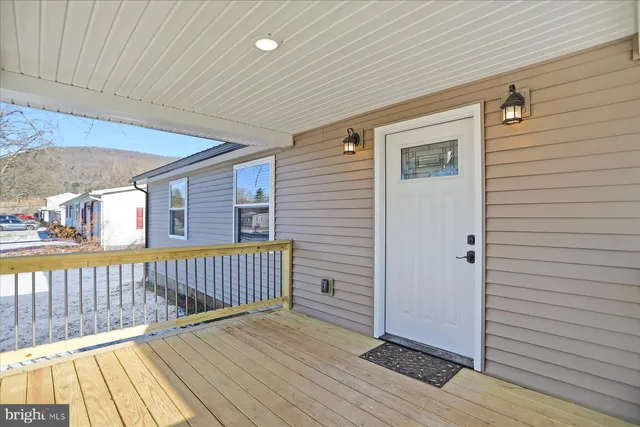 a view of empty room with wooden floor and furniture