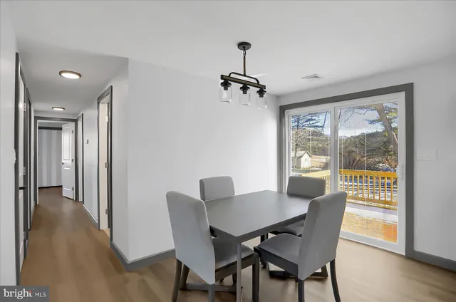 a view of an empty room with wooden floor and a ceiling fan