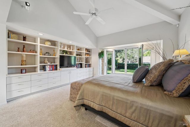 a bed sitting in a bedroom next to a window with a large window