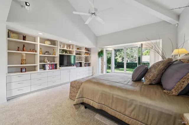 a bed sitting in a bedroom next to a window with a large window