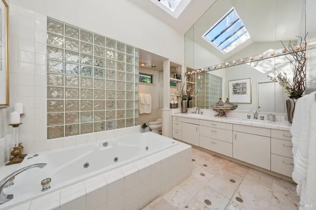 a bathroom with a bathtub sink and mirror