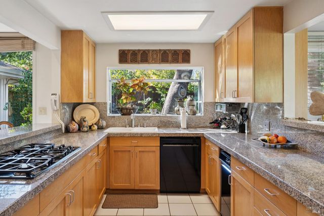 a kitchen with granite countertop a refrigerator and a stove top oven