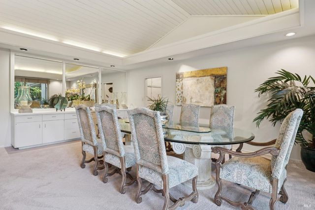 a view of a dining room with furniture and a potted plant