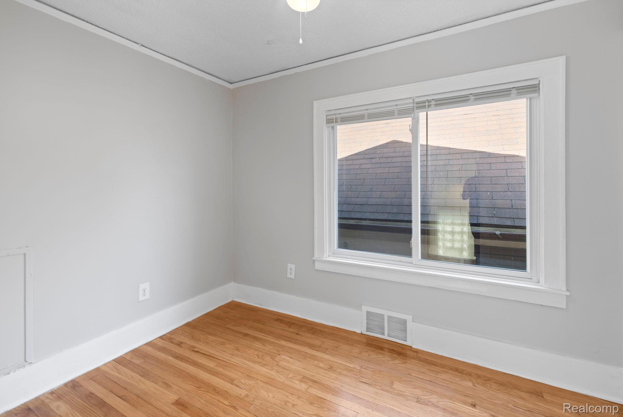 74 Pine Street River Rouge, MI 48218 - Photo 15 of 28 Spare room with crown molding and light wood-style flooring