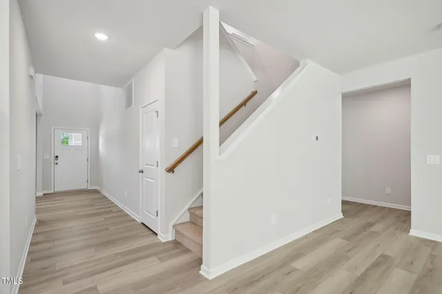 a view of a hallway with wooden floor and staircase