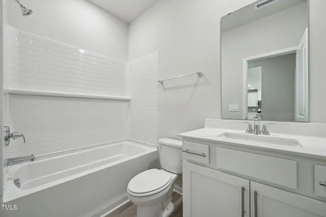 a bathroom with a sink toilet vanity and tub