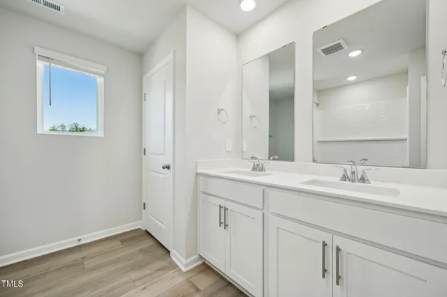 a bathroom with a double vanity sink and mirror