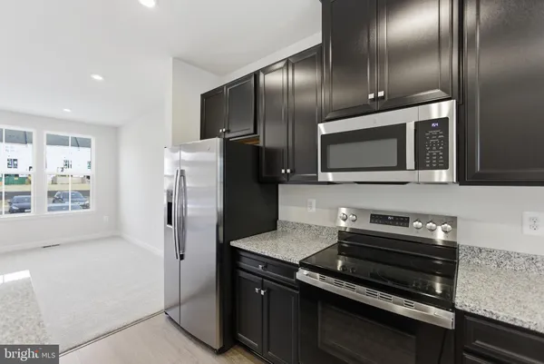 a kitchen with granite countertop stainless steel appliances and wooden cabinets