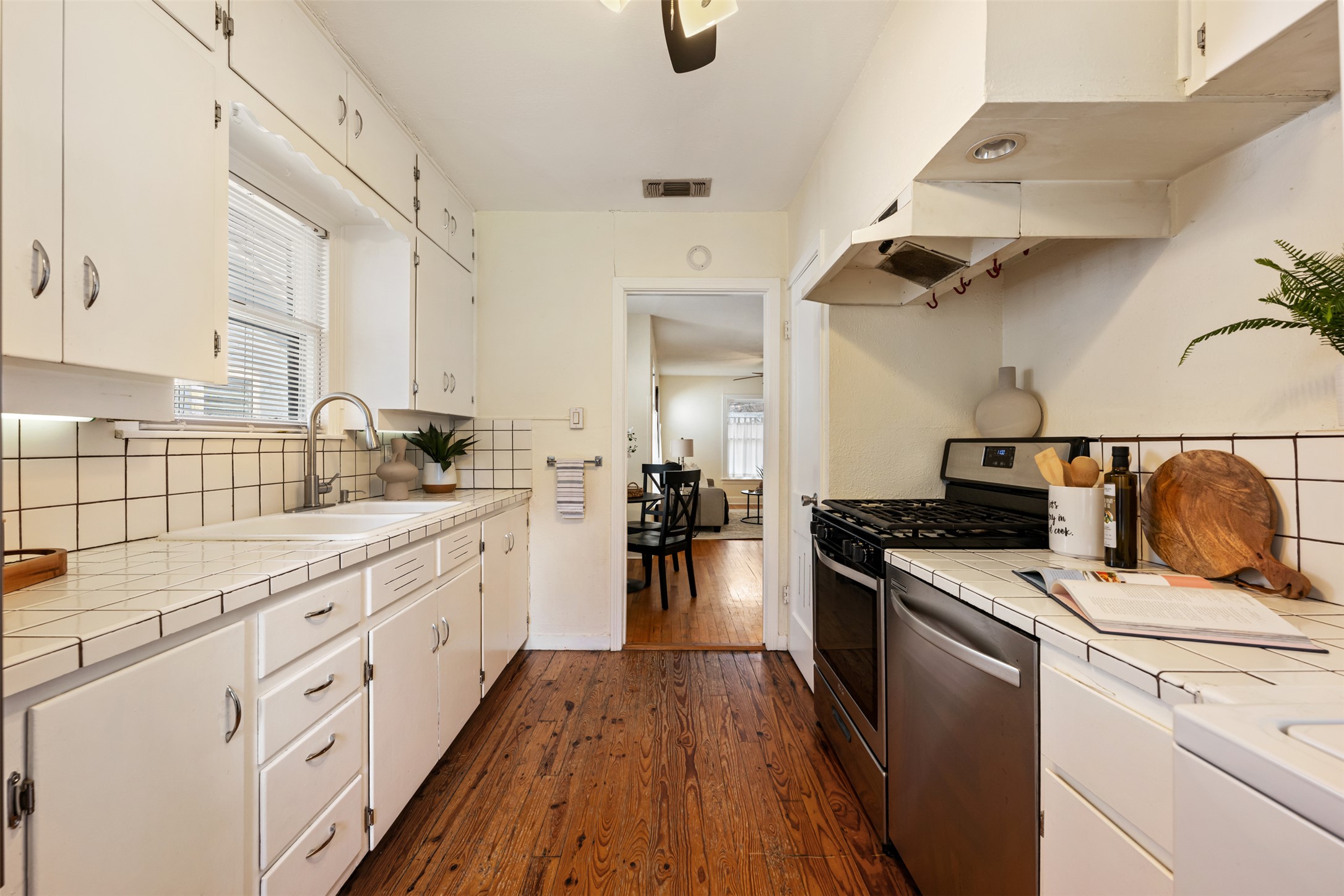 813 East 48th Street Austin, TX 78751 - Photo 17 of 37 a kitchen with cabinets wooden floor and stainless steel appliances