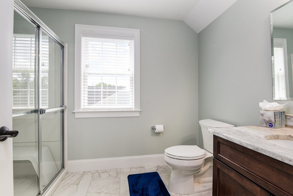 221 Valley Road Needham, MA 02492 - Photo 32 of 42 a bathroom with a granite countertop toilet a sink and a window