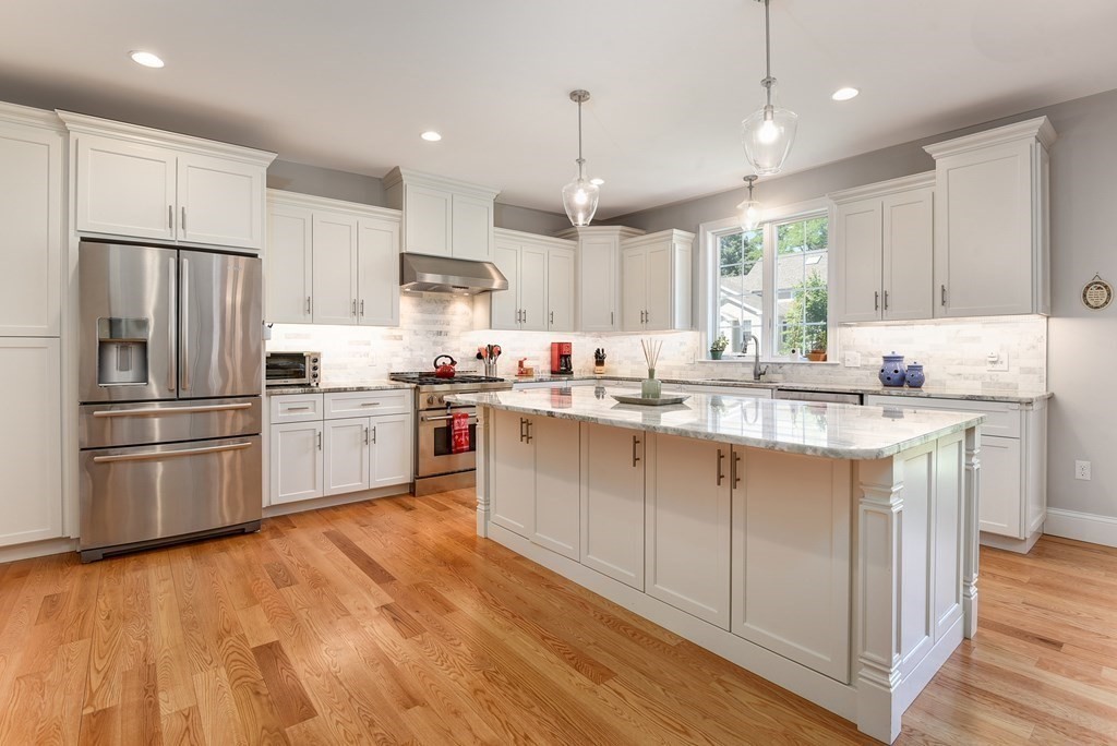 221 Valley Road Needham, MA 02492 - Photo 9 of 42 a kitchen with stainless steel appliances granite countertop a sink a stove a refrigerator and island with wooden floor