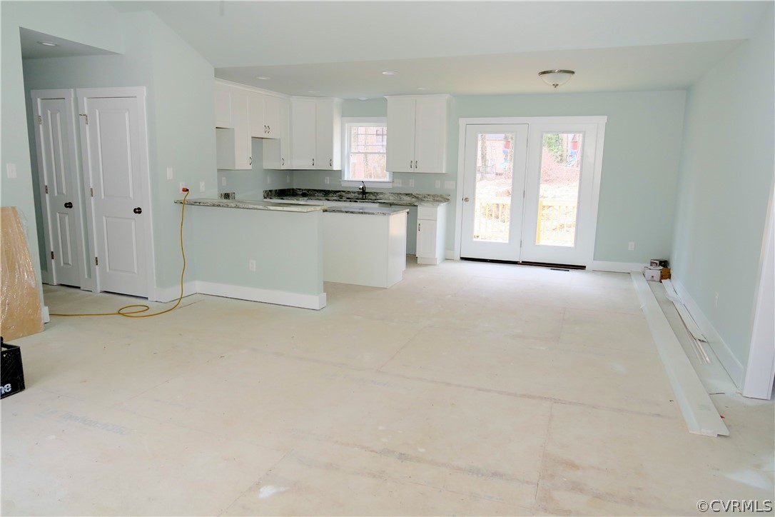 3824 Wood Dale Road Chester, VA 23831 - Photo 3 of 13 a large white kitchen with granite countertop a stove a sink a refrigerator and white cabinets with wooden floor