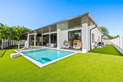 a view of a house with pool and chairs