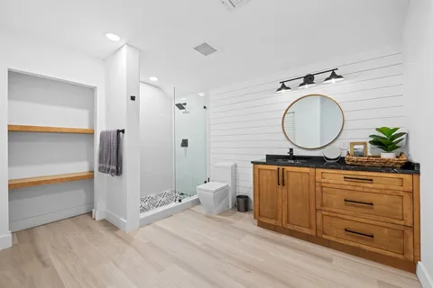 a bathroom with a granite countertop sink mirror vanity and toilet