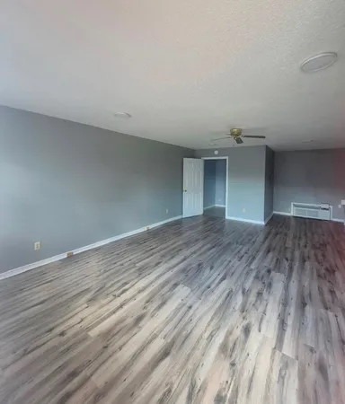 a view of empty room with wooden floor