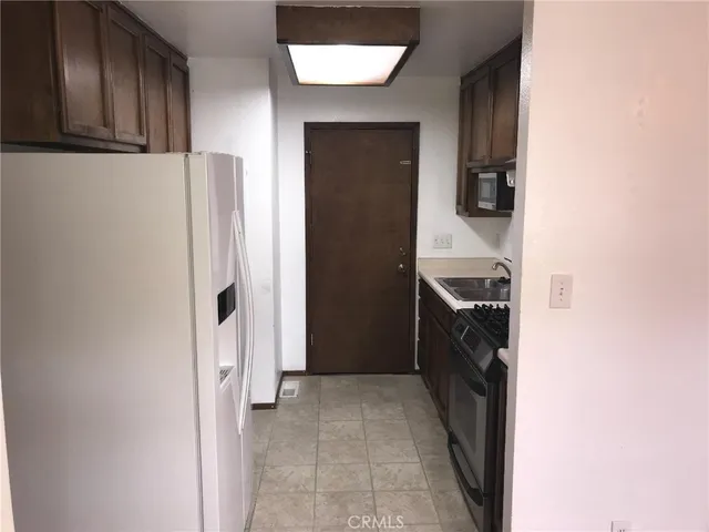 a walk in closet with wooden floor