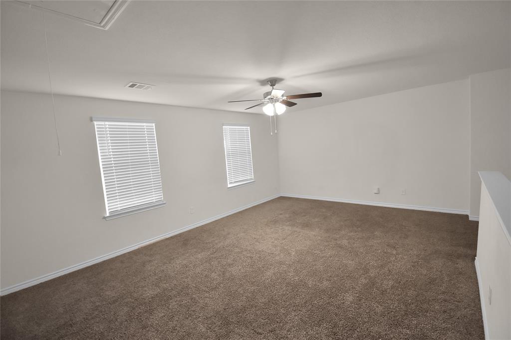 604 Gunsmoke Trail Princeton, TX 75407 - Photo 15 of 25 an empty room with windows and chandelier fan