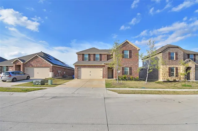 a view of big white house with a big yard and large trees