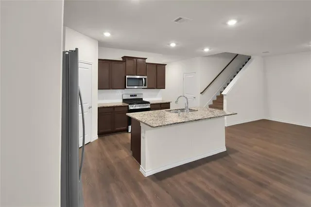 a kitchen with stainless steel appliances granite countertop a sink stove and refrigerator