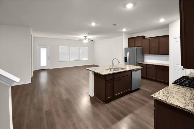 a kitchen with a sink cabinets and wooden floor