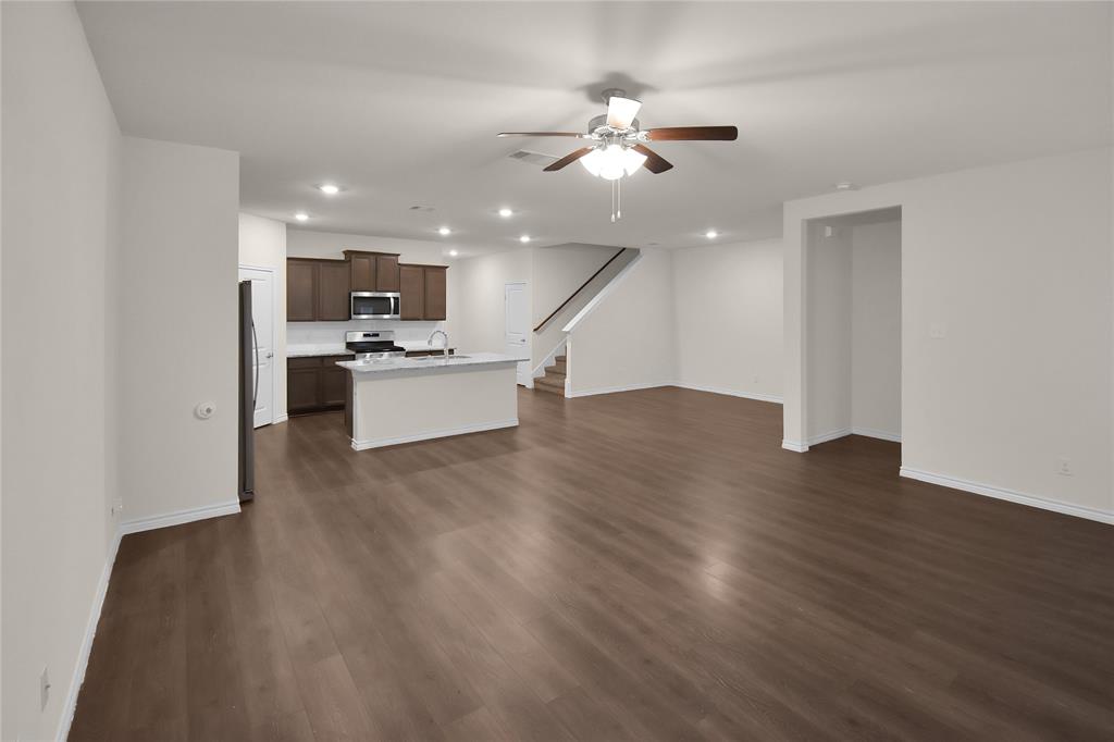 604 Gunsmoke Trail Princeton, TX 75407 - Photo 9 of 25 a view of living room with kitchen island stainless steel appliances wooden floor and living room view