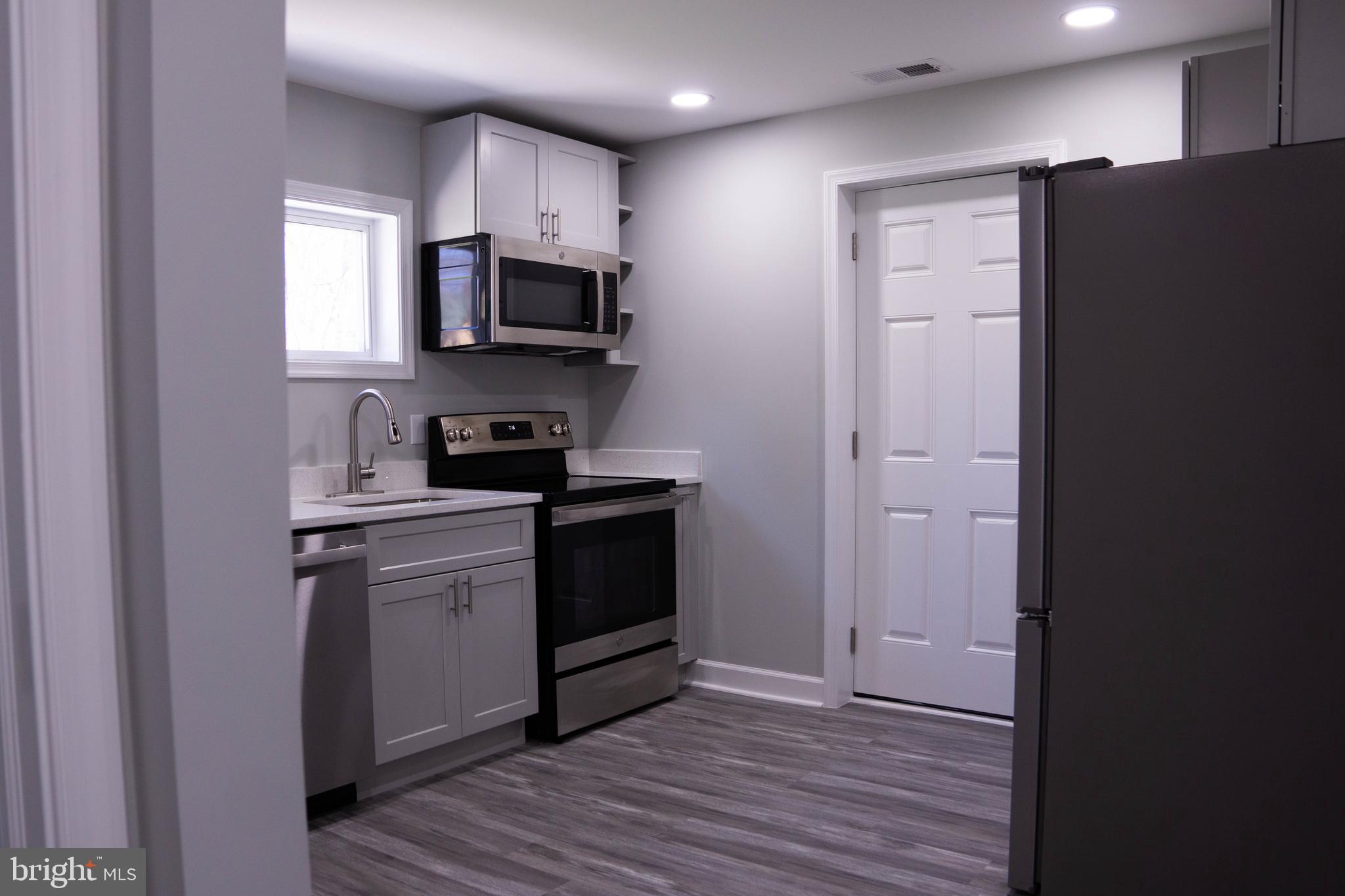 1009 Main Street, Unit 1 Fallston, MD 21047 - Photo 8 of 19 a kitchen with stainless steel appliances granite countertop a refrigerator and a stove top oven