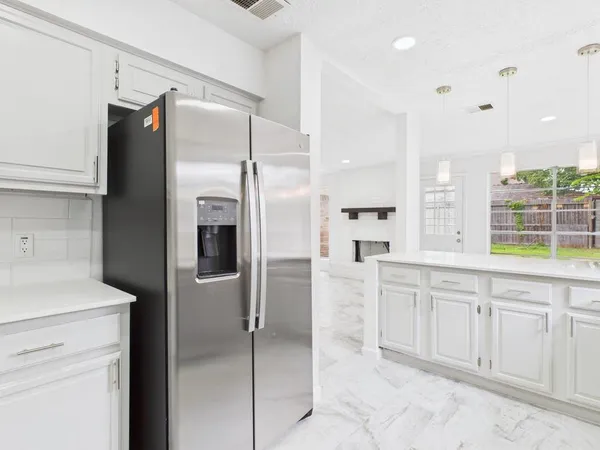 a kitchen with a stove a refrigerator and cabinets