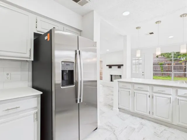 a kitchen with a stove a refrigerator and cabinets