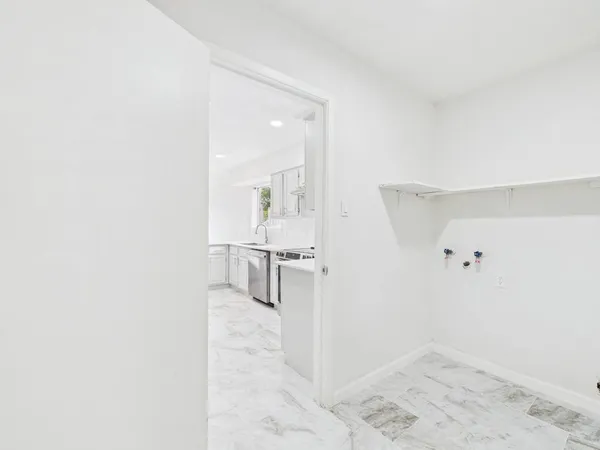 an empty room with a bathroom and a window